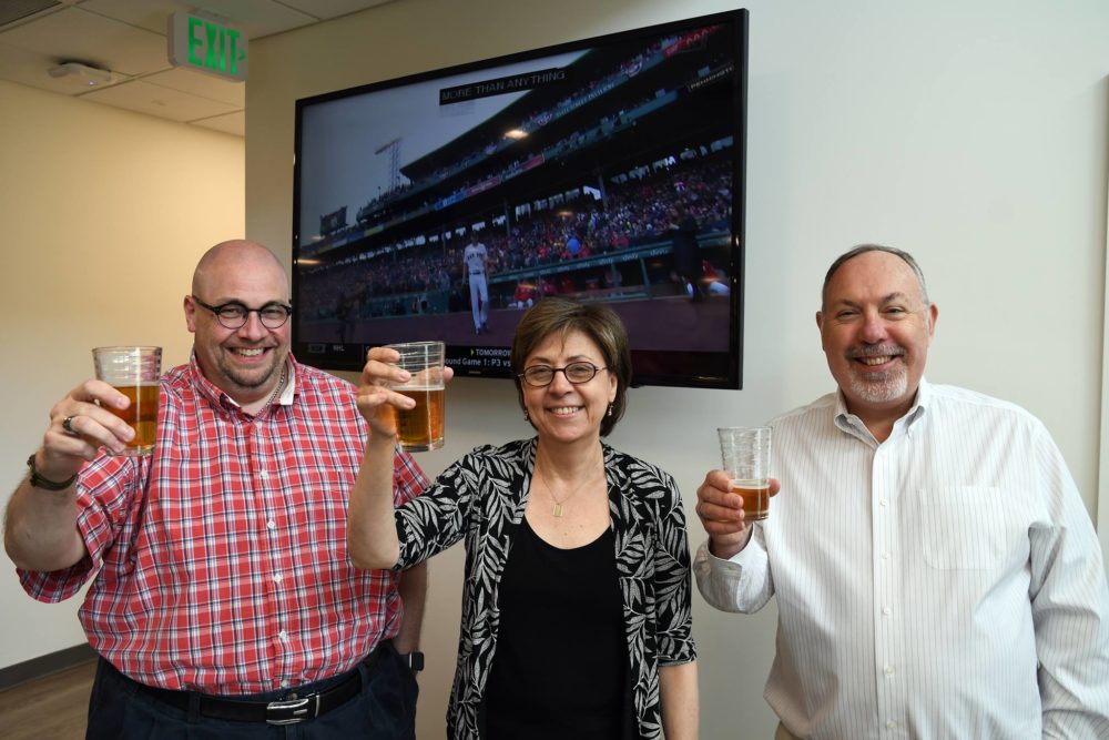 Three CapeSpace members raising a glass of beer